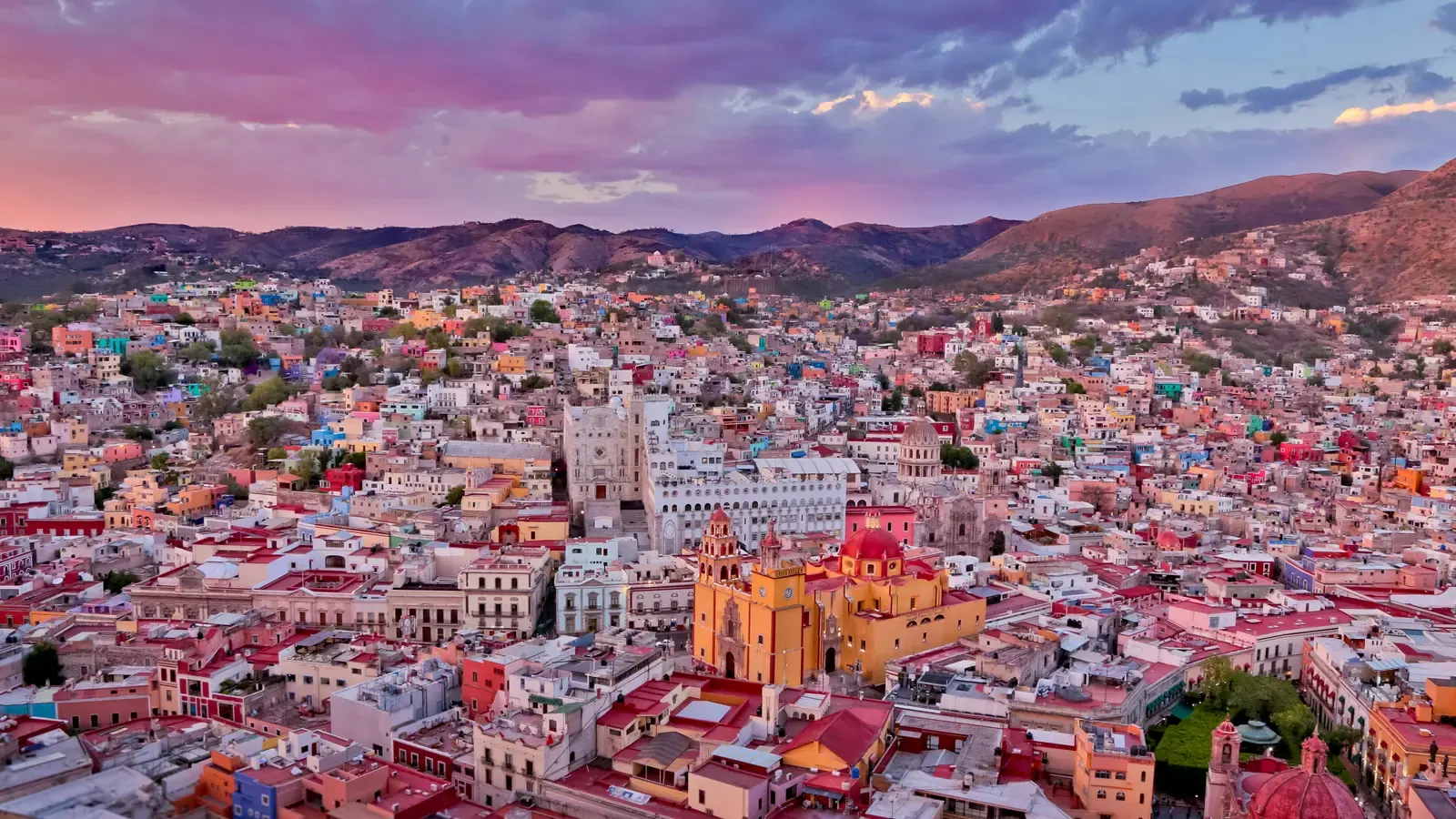 Case colorate pe dealurile orașului Guanajuato, Mexic, la apus.