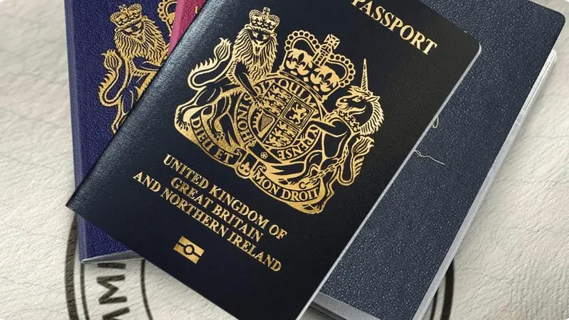 Three passports fanned out on a table, with a United Kingdom passport on top.