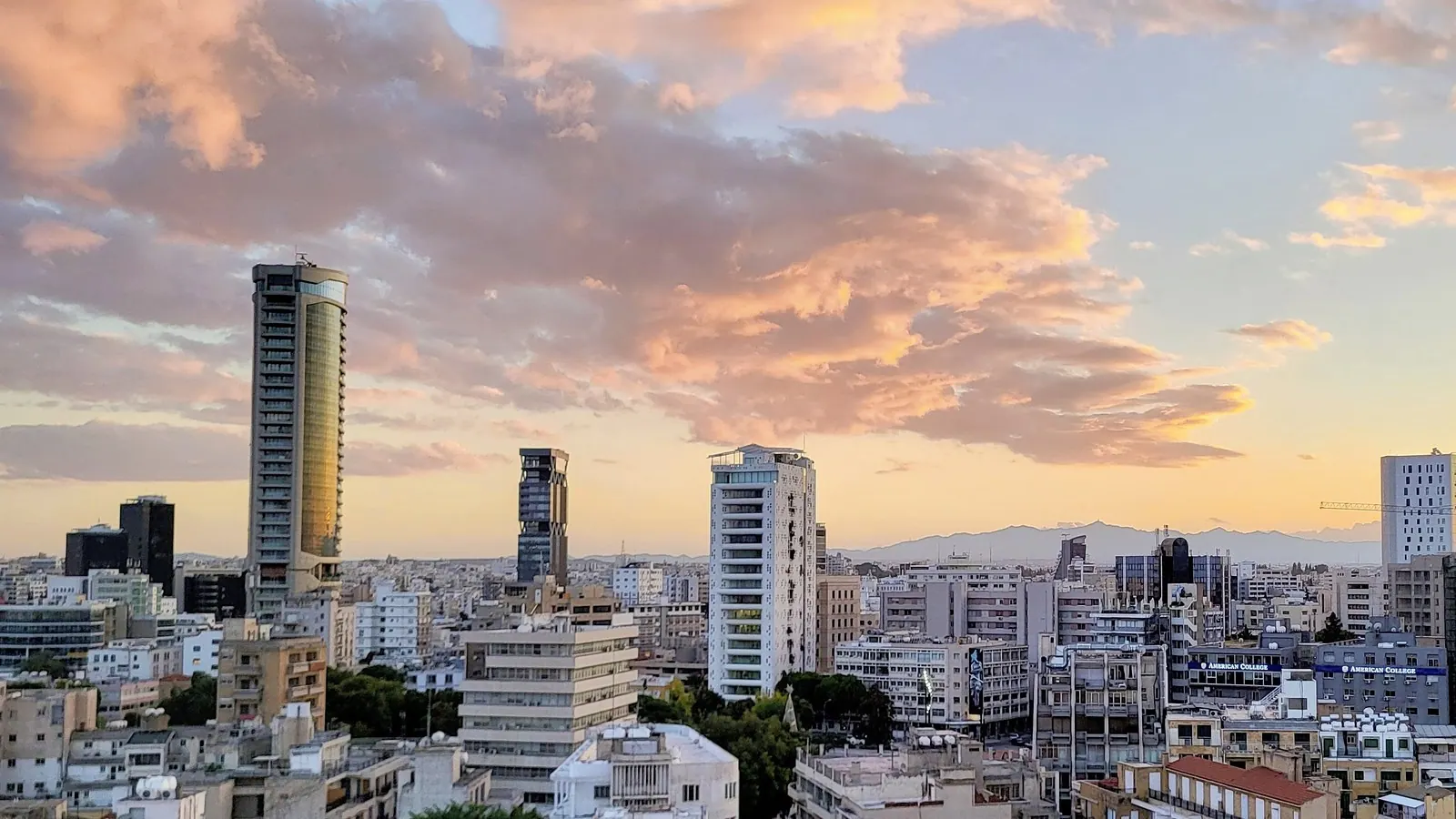 Nicosia business district towers under golden evening clouds